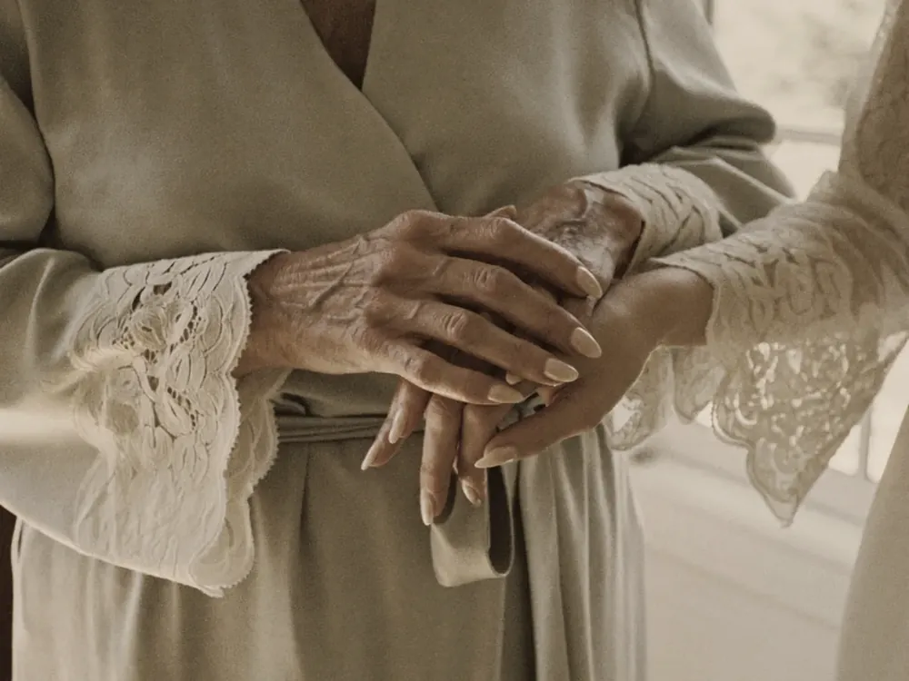 Manos de la madre de la novia sobre las de su hija el día de la boda, maquillaje de madrina en Gran Canaria